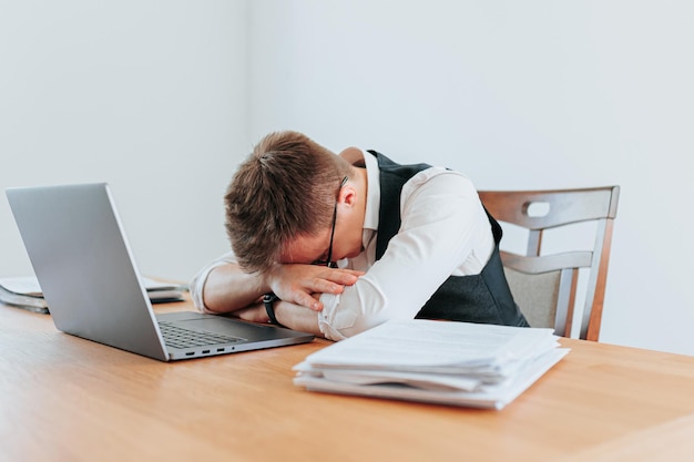 Een vermoeide kantoormedewerker doet een dutje aan zijn bureau, uitgeput van een lange dag problemen oplossen en stress