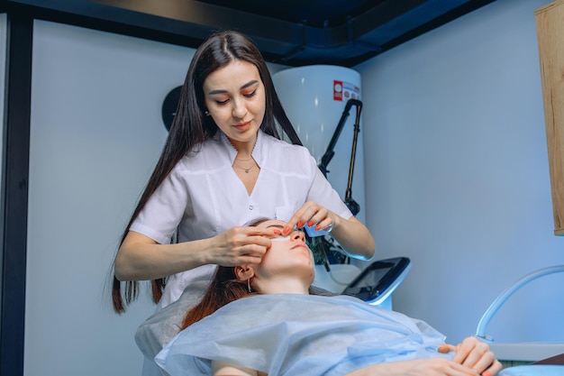 Een verpleegkundige procedure ter preventie van een gezwollen gezicht voor een jong meisje van een ervaren schoonheidssalonmedewerker.