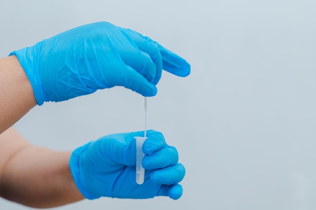 Een verpleegster gebruikt een wattenstaafje gedrenkt in een antigeen-ATK-testkit als testkit voor COVID19