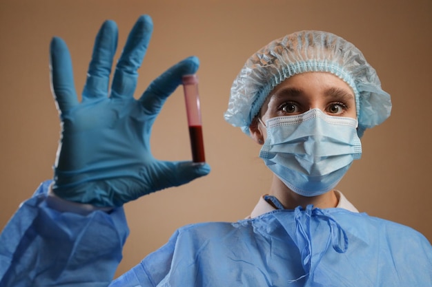 Een verpleegster houdt een reageerbuisje vast met een coronavirus positief bloedmonster 2019 nCoV pandemie