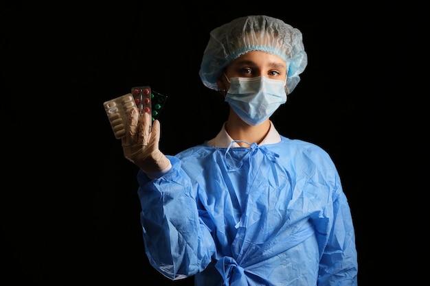 Een verpleegster-viroloog met een masker houdt pillen in zijn handen Coronavirusvaccin Quarantaine