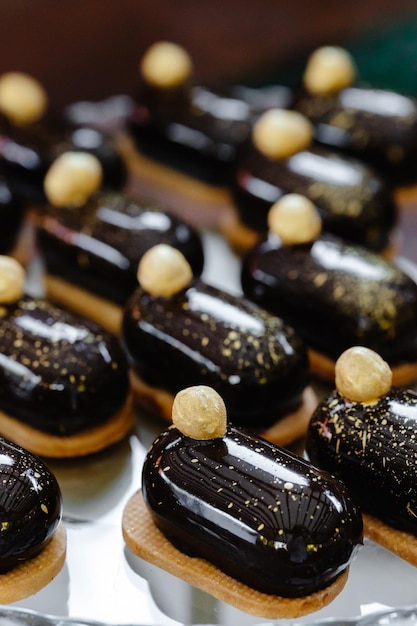 Een verscheidenheid aan eclairs met chocoladeglazuur en noten op de feesttafel