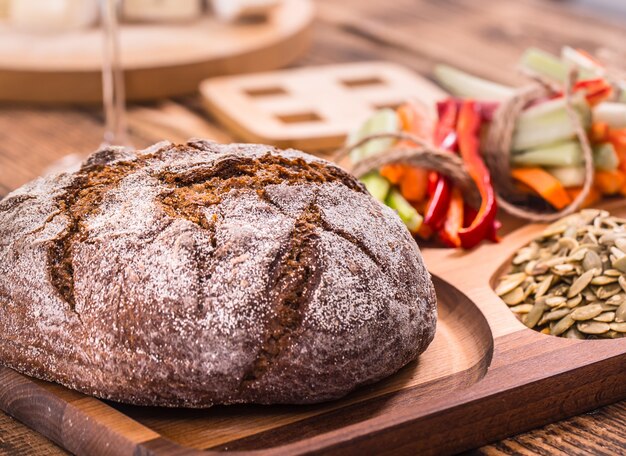 Een verse ronde van donker brood op een houten plaat