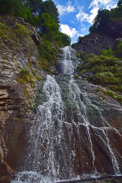 Een verticale opname van een waterval door een bergachtig landschap