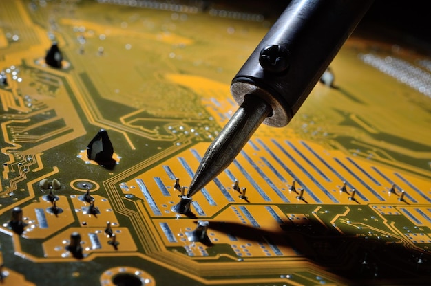Een verwarmde soldeerbout soldeert een klein contact op de chip