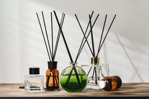 Een verzameling aromatische riet diffusers op een houten tafel tegen een neutrale achtergrond
