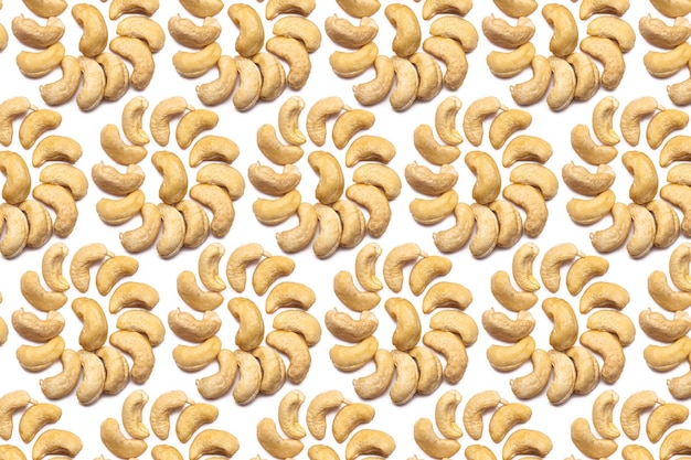 Een verzameling cashewnoten ligt in de vorm van een cirkel of zon op een geïsoleerde witte achtergrond met een uitknippad