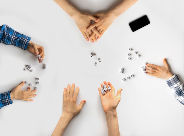 Een vier vrienden die het dobbelspel spelen in een casino, winnen of verliezen concept met plezier op het feest