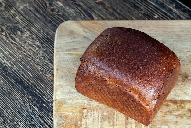 Een vierkant roggebrood op een snijplank