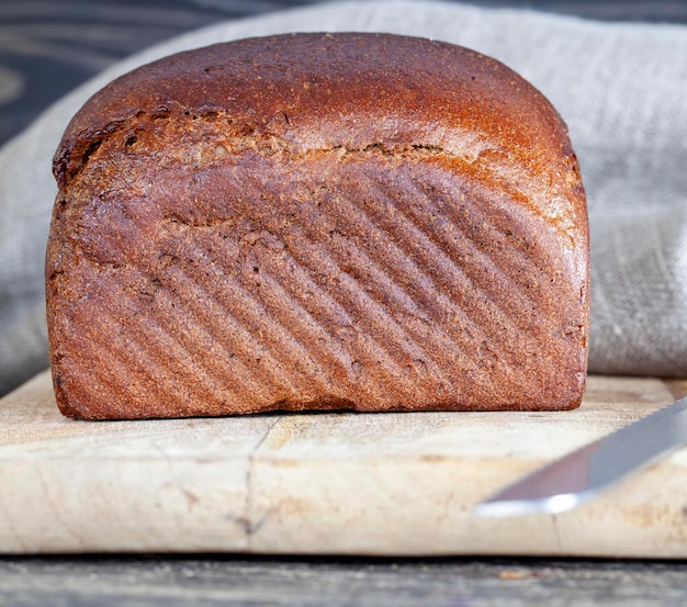 Een vierkant roggebrood op een snijplank