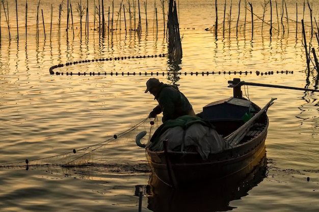 Foto een visser in een boot met een net in het water