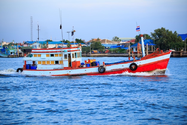 Een vissersboot is teruggekomen van de oceaan en voer op een brede rivier in het zuiden van thailand