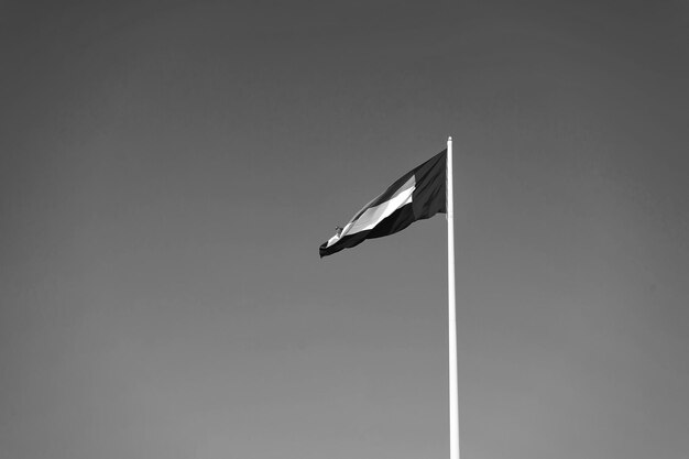 Een vlag van de Verenigde Arabische Emiraten wappert tegen een schone en rustige hemel De VAE viert elk jaar zijn nationale dag op 2 december