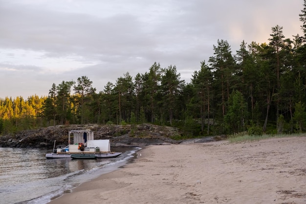 Een vlot aan de oever van een zandig bosmeer in Karelië zonsondergang avondlicht