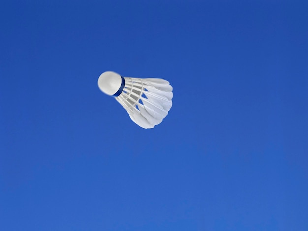 Een voetbal die in de lucht is geschoten met een blauwe hemelachtergrond