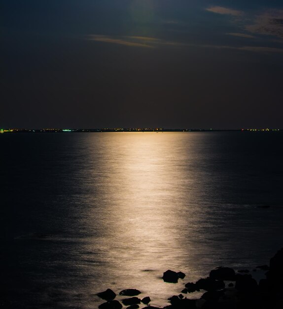 Een volle maan is zichtbaar boven het water.