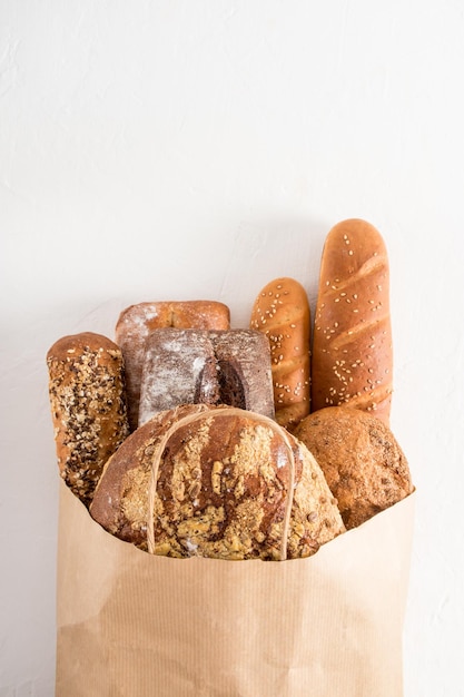 Een volle zak vers gebakken brood in een bakkerij op een witte achtergrond Concept van nul afval eco winkelen en levering verticale vlakke weergave