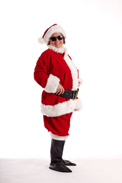 Een volwassen vrouw verkleed als kerstman lachend op camera tegen een witte achtergrond.