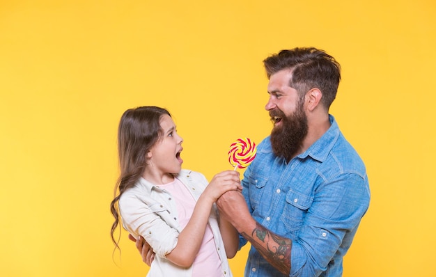 Een voor mij geen voor jou. Vader neemt lolly van ongelukkig kind. Vechten voor swirl lolly op stok. Zoet eten. Dessertsnack. Snoepwinkel. Snoepwinkel en zoetwaren. Kan niet wachten om lolly te likken.