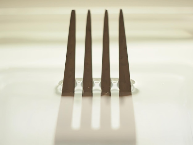 Een vork wordt getoond met de schaduw van de andere vorken.