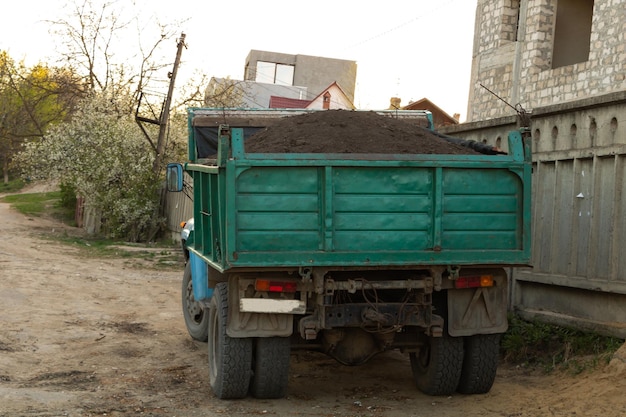 Een vrachtwagen vol met zwarte grond voor de tuin