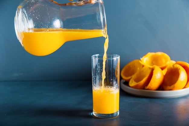 Een vreemde hand vult verse jus d'orange tot glas