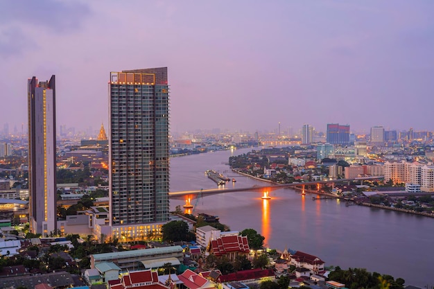 Een vroeg ochtendzicht op de Bangkok-rivier met moderne bedrijfsgebouwen langs de Chao Phraya-rivier