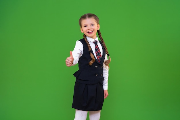 Een vrolijk schoolmeisje in een schooluniform op een geïsoleerde achtergrond