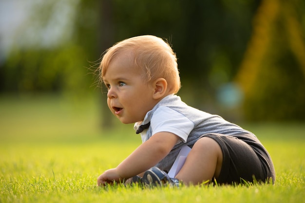 Een vrolijke baby zit op het grasveld