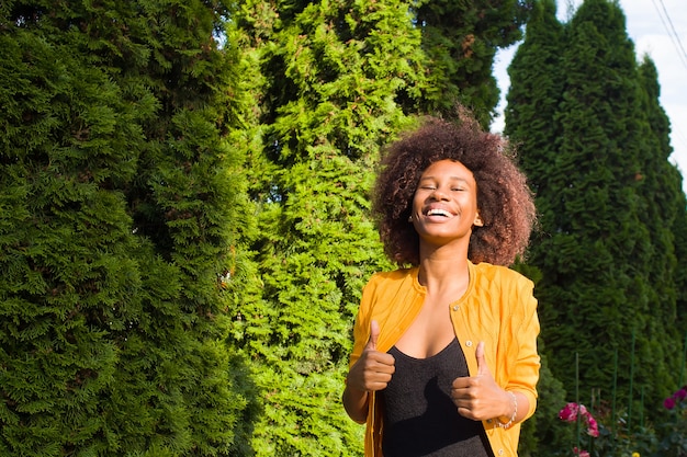 Een vrolijke en jonge Afro-Amerikaanse vrouw loopt over straat