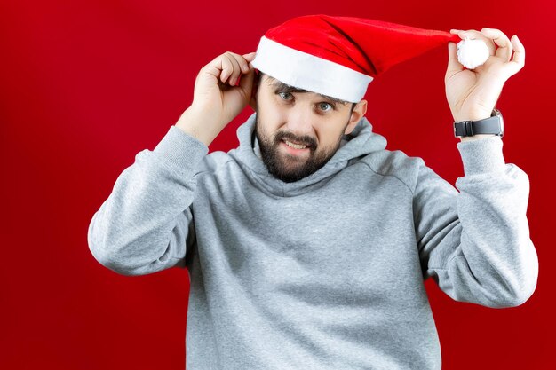 Een vrolijke man met een rode kerstmuts houdt een elektronische stabilisator in zijn hand waarop de telefoon van een man een selfie maakt