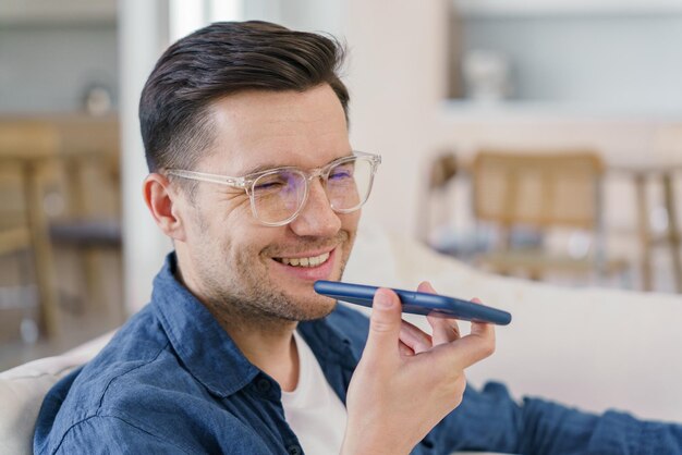 Een vrolijke man praat aan de telefoon zijn warme glimlach weerspiegelt een comfortabele ontspannen sfeer