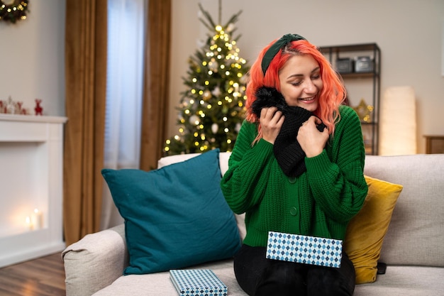 Een vrolijke vrouw kreeg haar droom kerstcadeau ze haalt een prachtige wollen muts uit de doos