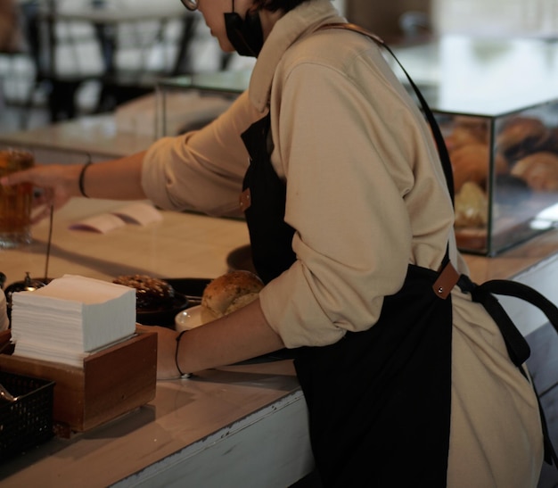 Een vrouw bakt brood aan een toonbank.