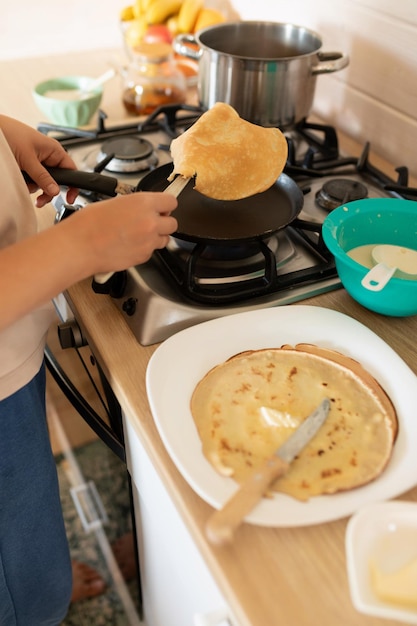 Een vrouw bakt pannenkoeken op een bakplaat