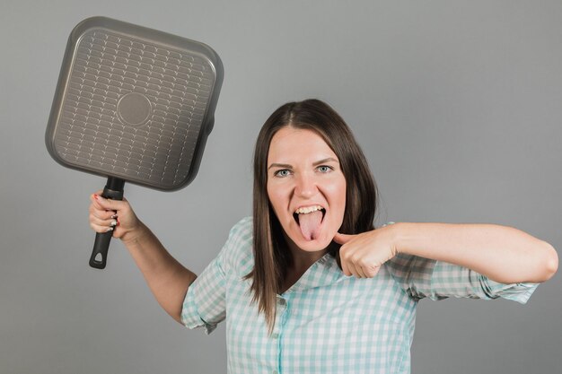 Een vrouw bedreigt je met een koekenpan Op een grijze achtergrond