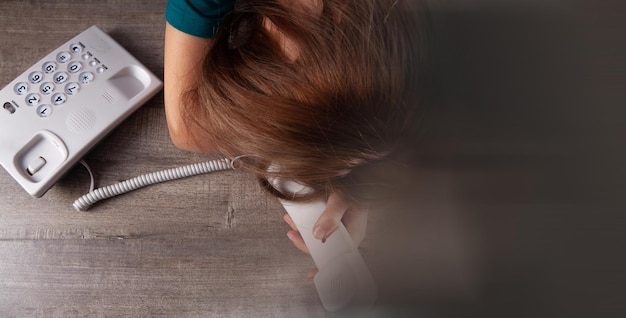 Een vrouw belt een nummer op een vaste telefoon thuis