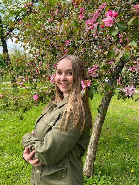 Een vrouw bij een bloeiende Malus Domestica boom Lentemeisje bij de appelboom