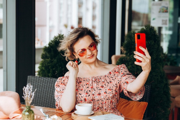 Een vrouw die aan de telefoon praat Een vrouw met een mobiele telefoon zit in een café een vrouw in een jurk en een hoed in een café