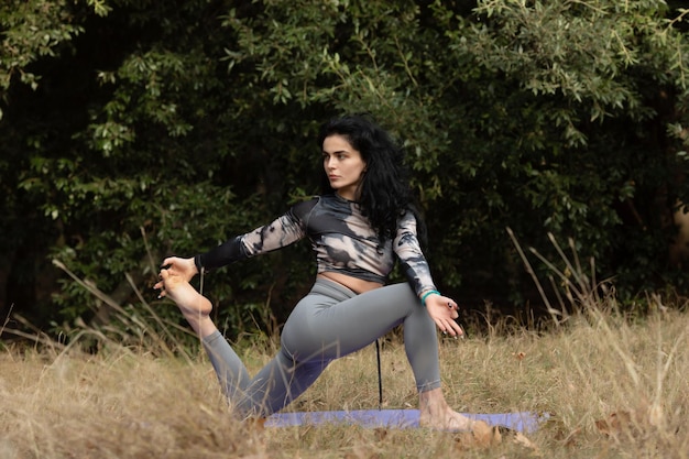 Een vrouw die alleen yoga beoefent in het bos