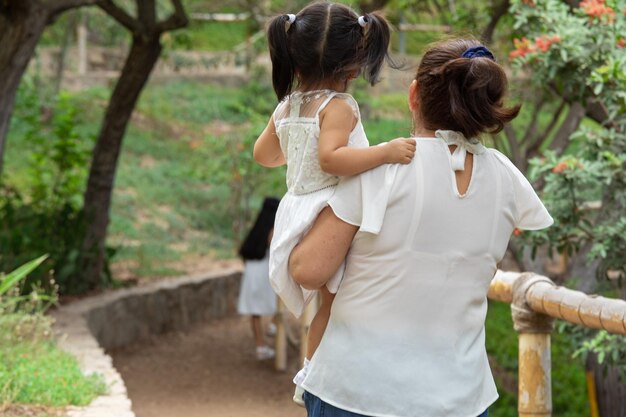 Foto een vrouw die een baby op haar rug draagt