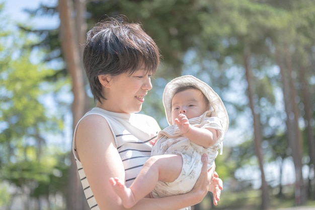 Een vrouw die een baby vasthoudt in een park