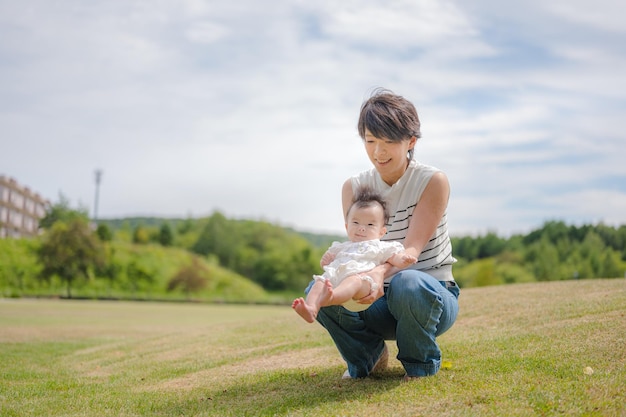 Een vrouw die een baby vasthoudt in een veld