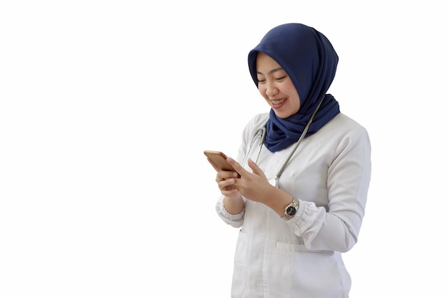 Een vrouw die een blauwe hijab draagt, gebruikt een smartphone.