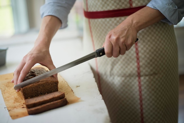 Een vrouw die een gebakken chocoladetaart snijdt