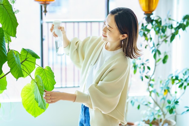 Een vrouw die een kamerplant water geeft