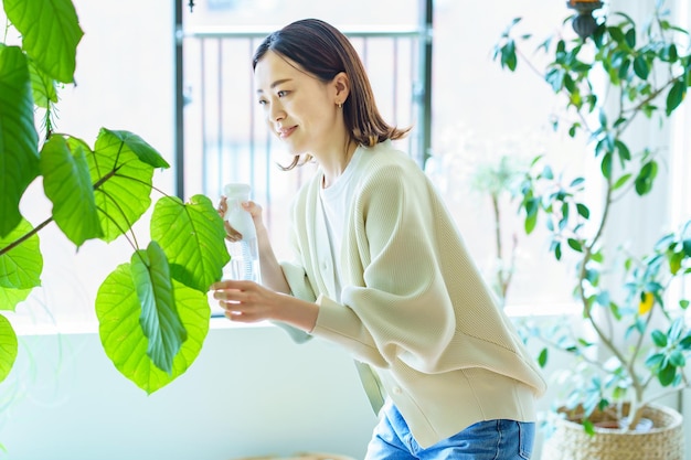 Een vrouw die een kamerplant water geeft