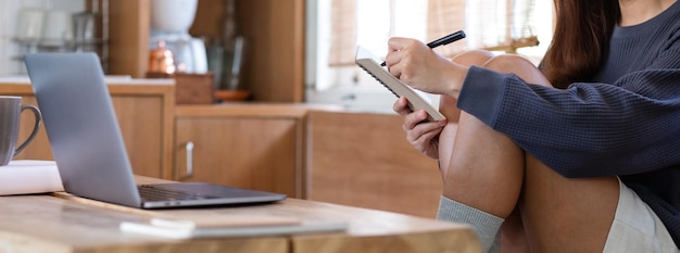 Foto een vrouw die een laptop gebruikt om thuis online te werken of te studeren