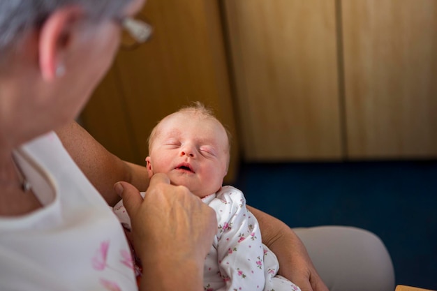 Een vrouw die een slapende pasgeboren baby vasthoudt