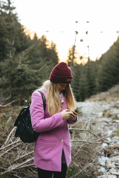 Een vrouw die een telefoon in de bergen gebruikt om haar locatie te zien